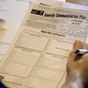 Person holds copy of FEMA family communication plan document.