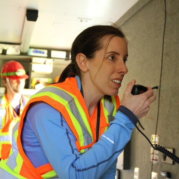 Woman holding an amateur radio transmitter. She is a Portland Neighborhood Emergency Team member. 