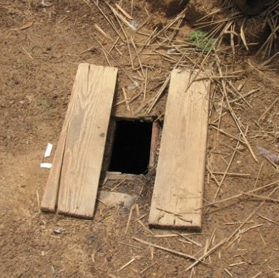 Latrine hole in the ground with two boards for standing on.